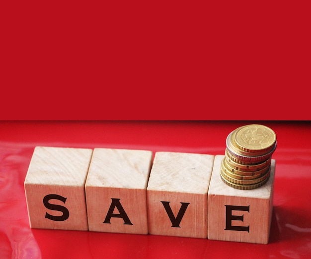 Word Save na drewnianych kostkach z monetami Koncepcja biznesowa oszczędzania pieniędzy i podatków