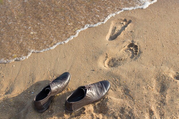 Work Life Balance Concept Biznesmen zdejmuje buty robocze i zostawia je na piaszczystej plaży