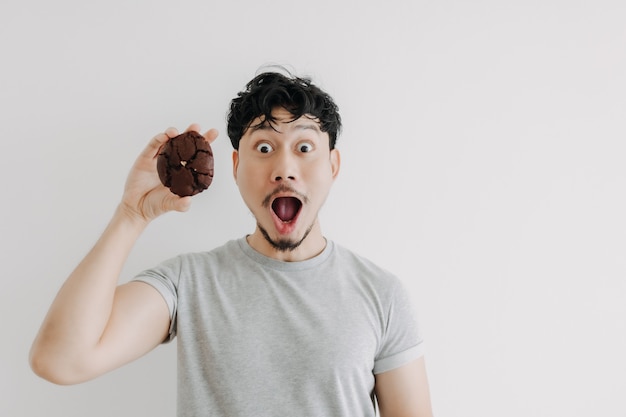 Wow i zszokowana twarz mężczyzny jest podekscytowana ogromnym czekoladowym ciastkiem