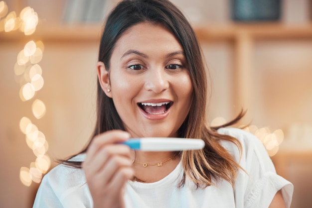 Wow podekscytowana lub kobieta z wynikami testu ciążowego, czytając kij płodności w domu ze szczęśliwym uśmiechem Twarz osoby w ciąży lub zaskoczonej w macierzyństwie zszokowanej macierzyństwem lub przyszłymi wiadomościami rodzinnymi