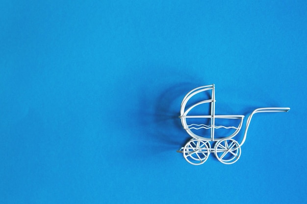 Wózek dziecięcy Vintage zabawka na niebieskim tle. wózek zabawkowy