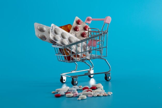 Wózek w supermarkecie z kartami lekarskimi i pigułkami na niebieskim tle