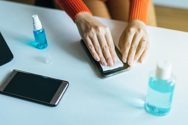 Zdjęcie wręcza kobiety czyści brudnego telefon komórkowego na ekranie, środki zapobiegawcze przeciw koronawirusowi