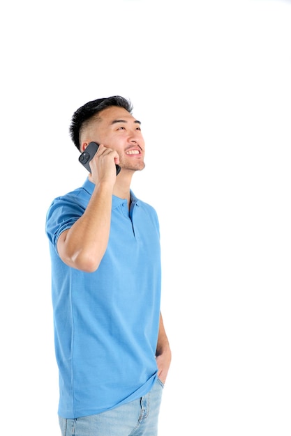 Zdjęcie wschodni młody człowiek uśmiecha się rozmawiając na smartfonie na białym tle
