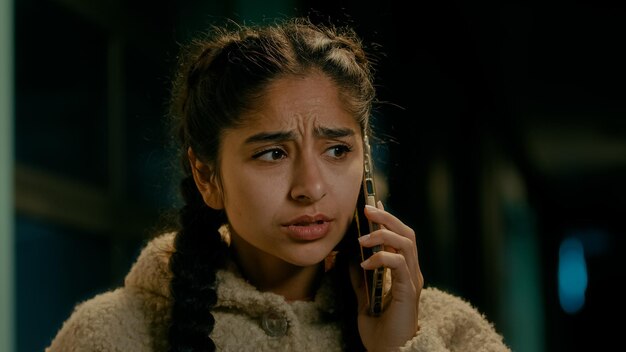 Wściekła, smutna, arabska kobieta, młoda dziewczyna, klientka, studentka, freelancer, rozmawia przez telefon na świeżym powietrzu w wieczornym mieście