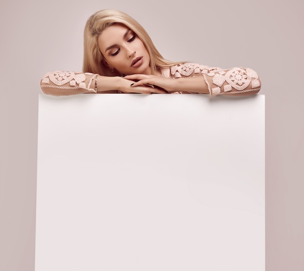 Wspaniała blondynki kobieta trzyma pustego billboard