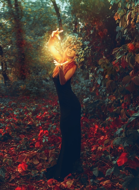 Zdjęcie wspaniała młoda wiedźma czaruje w lesie na zewnątrz