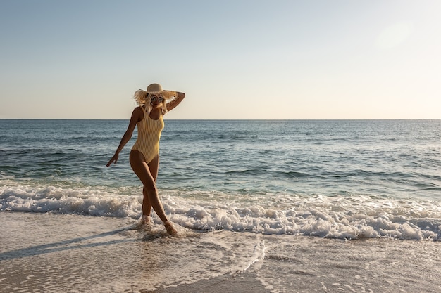 Wspaniała modelka w stroju kąpielowym na piaszczystej plaży