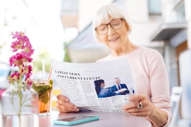 Zdjęcie wspaniała wiadomość. selektywne skupienie się na świeżej gazecie czytanej przez starsze kobiety, które się uśmiechają
