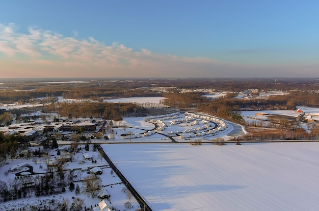 Wspaniałe zimowe krajobrazy dachowe pokryte śniegiem z widokiem z lotu ptaka z miasteczkiem mieszkalnym