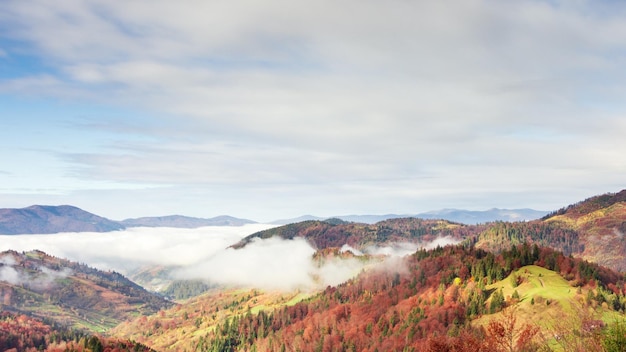 Wspaniały jesienny krajobraz z pięknym błękitnym niebem i majestatycznymi chmurami Las o zachodzie słońca Piękny sezon jesienny Las w górach Zachód słońca w górach Pomarańczowe kolory Duchowość Inspiracja Koncepcja wakacji