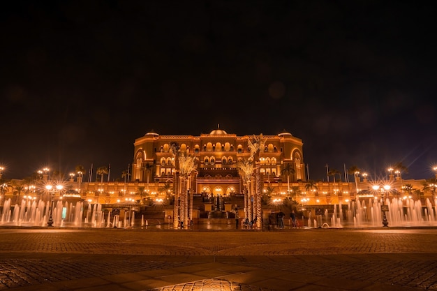 Wspaniały widok na hotel - Emirates Palace - nocą. Złote rozjaśnienie.