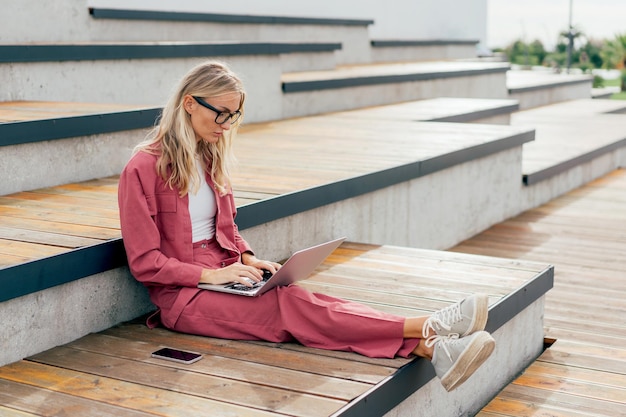 Współczesna kobieta biznesowa pracuje zdalnie na laptopie w parku publicznym