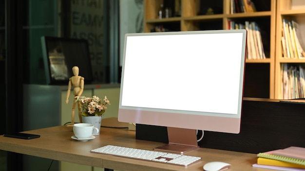 Współczesne miejsce pracy z filiżanką kawy na komputer PC laptop i artykułami biurowymi na drewnianym stole Pusty ekran na tekst reklamowy