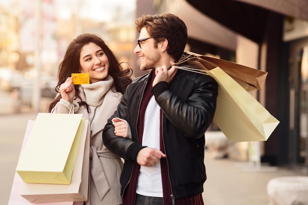 Wspólne zakupy Kobieta pokazująca mężowi kartę kredytową