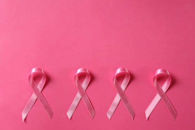 Wstążki świadomości raka piersi na różowym tle