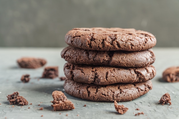 Wtykający czekoladowi brownie ciastka na popielatym betonowym tle