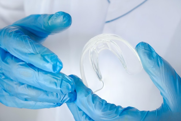 Wybielanie zębów zdrowe proste wyjmowane aparaty ortodontyczne w dłoni lekarza niewidoczna taca na zęby