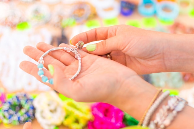 Wybór biżuterii damskiej Na kobiecej dłoni leżą ozdoby bransoletki
