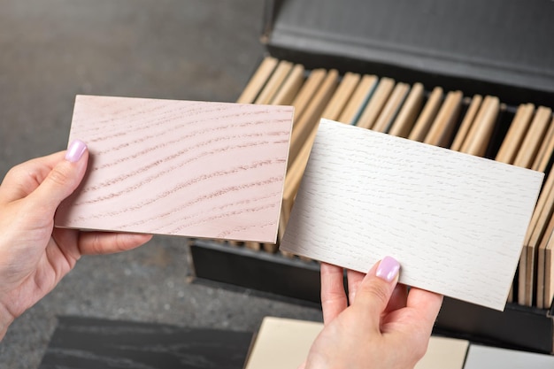 Wybór koloru podłogi z próbek drewna Kobieta projektantka wybiera kolor podłogi za pomocą próbek różnych odcieni Koncepcja wyboru nowej podłogi Zdjęcie wysokiej jakości