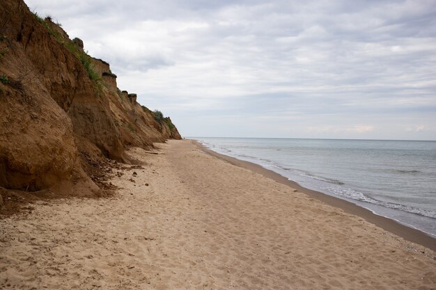 Wybrzeże Morza Czarnego, widok na piaszczystą plażę, wysoki klif, lekkie fale morskie w letni dzień