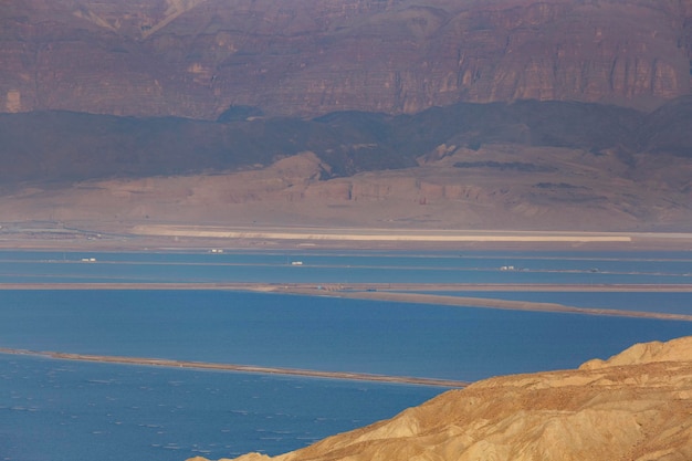 Zdjęcie wybrzeże morza martwego w ein bokek izrael białe kryształy soli na zewnątrz i na dnie turkusowo czysta woda wybrzeża morza mrtwego kryształy solne przy zachodzie słońca tekstura morza mёртwego wybrzeżu morza słonego izrael