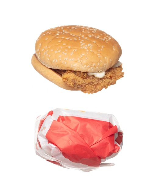 Zdjęcie wybuch muchy w burgerze z kurczaka kurczaka burgers owinięte papierem spadają gorący chleb kurczak hamburger fast food rzucają rozpryskiwanie w powietrze białe tło izolowane szybkie zamrażanie migawki