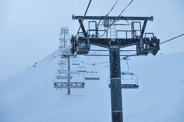 Wyciąg krzesełkowy z wysokimi metalowymi słupami do wspinaczki narciarzy na szczyt góry Grandvalira Andorra