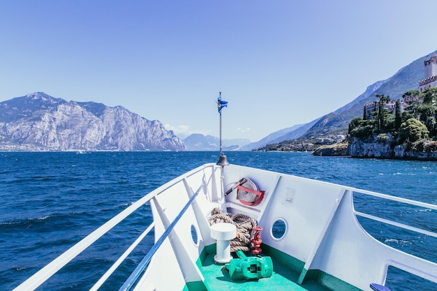 Wycieczka łodzią Widok z dziobu łodzi na lazurową wioskę i pasmo górskie Lago di Garda Włochy