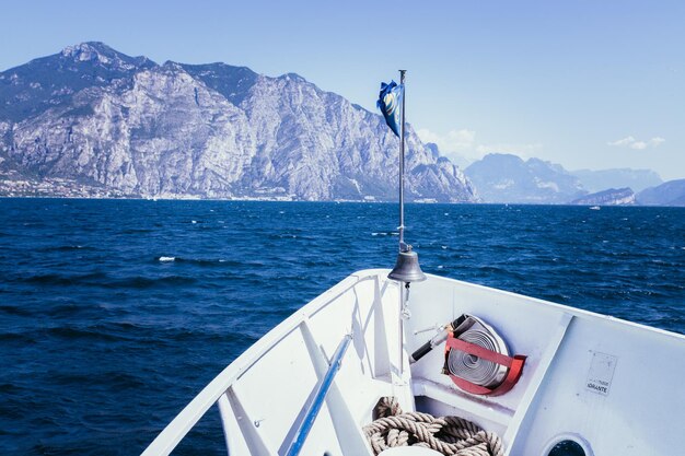 Wycieczka łodzią Widok z dziobu łodzi na lazurową wodę i pasmo górskie Lago di Garda Włochy