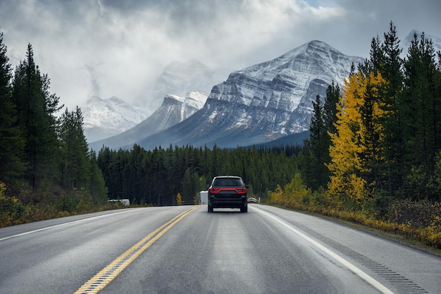 Zdjęcie wycieczka po autostradzie z górami skalistymi w jesiennym lesie w parku narodowym banff, kanada