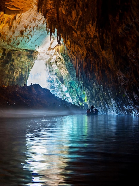 Wycieczka przez turystów łodzią w jaskini z podziemnym jeziorem Melissani na wyspie Kefalonia w Grecji