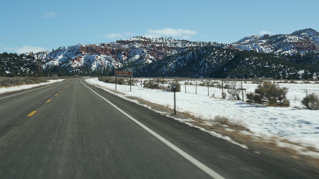 Wycieczka samochodowa w USA z Syjonu do Bryce Canyon Jazda samochodem w Utah autostopem podróżowanie po Ameryce trasa do lasu dixie zima lokalna podróż spokojna atmosfera i ośnieżone góry widok z samochodu