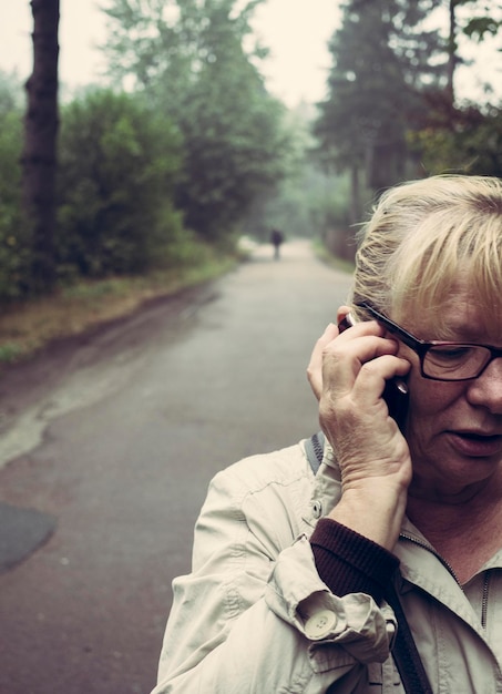 Wycięte zdjęcie kobiety rozmawiającej przez telefon komórkowy na ulicy