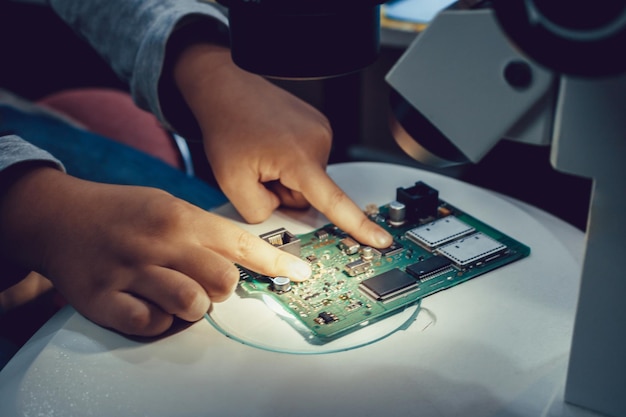 Wycięte zdjęcie technika dostosowującego płytę obwodową na slajdzie mikroskopowym w pomieszczeniu