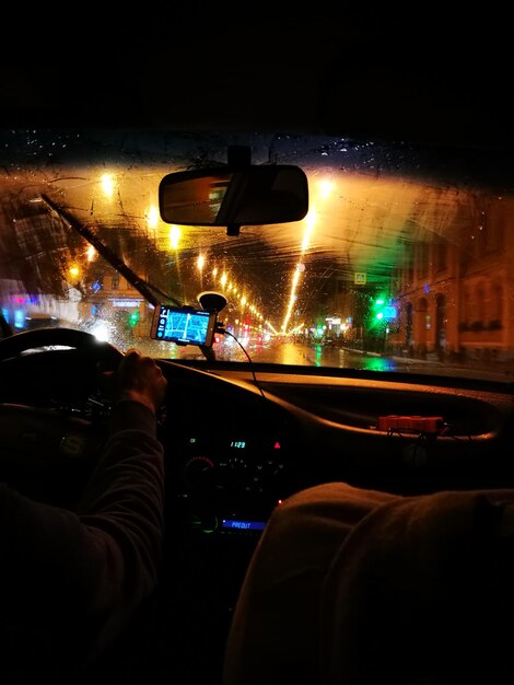 Zdjęcie wycięty obraz mężczyzny jeżdżącego samochodem w mieście w nocy