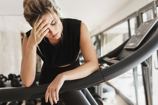 Zdjęcie wyczerpana wysportowana kobieta po treningu fitness na siłowni