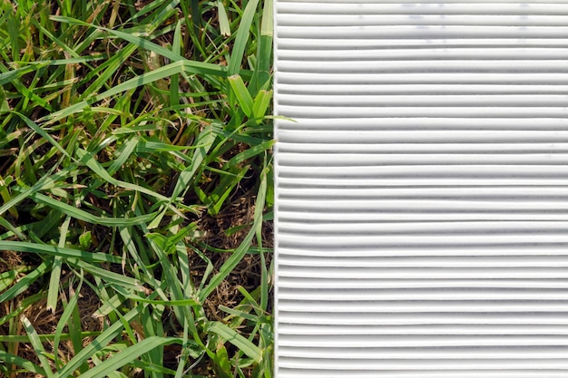 Zdjęcie wyczyść biały fragment filtra powietrza nad zieloną trawą