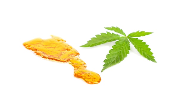 Wyizolowane wysokiej zawartości kawałki żółtego wosku z konopi i koncentratu marihuany z zielonych liści