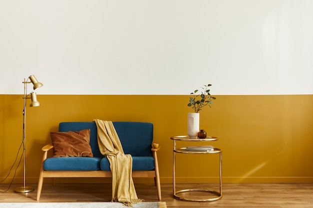 Wyjątkowy salon w nowoczesnym stylu z designerską sofą, eleganckim złotym stolikiem kawowym, kopią przestrzeni, kwiatami w wazonie