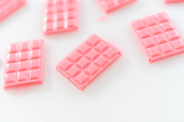Wyjmowanie mini różowych czekoladek z silikonowej foremki na czekoladki.