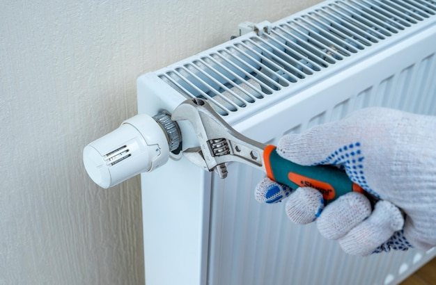 Zdjęcie wyłączanie termostatu na grzejniku w celu zaoszczędzenia energii ze względu na wzrost kosztów ogrzewania oszczędności na ogrzewaniu i wzrost kosztów energii