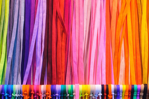 Zdjęcie wymieszaj kolorowe wiszące tkaniny tekstylne w pionowe paski na stojaku tekstura wielobarwnych tkanin z bliska