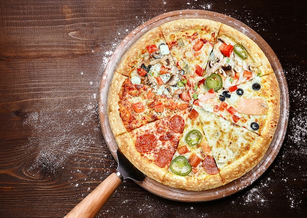 Wymieszaj osiem różnych pizzy na drewnianej powierzchni. koncepcja menu wyboru i różnorodności