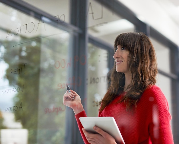 Wymyślanie pomysłów Ujęcie biznesmenów piszących na szklanej ścianie w biurze