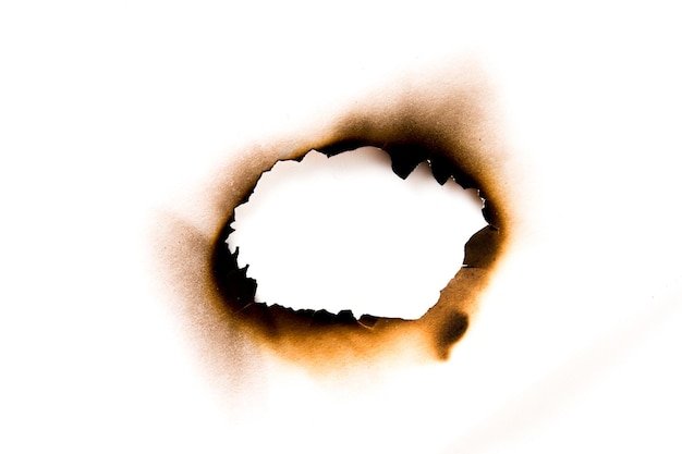 Zdjęcie wypalone dziury w kawałku papieru na białym tle