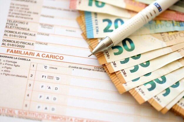 Wypełnianie włoskiego formularza podatkowego za pomocą długopisu i banknotów euro