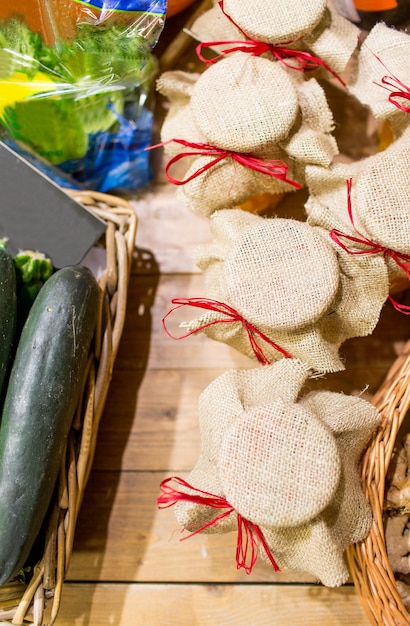 wyprzedaż, zakupy, styl rustykalny i koncepcja ekologicznego jedzenia - słoiki z miodem ozdobione worze i warzywami na bio market