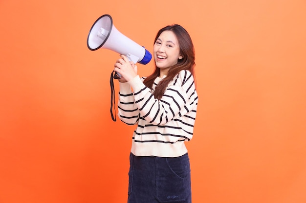 Wyraz twarzy azjatyckiej kobiety krzyczącej uśmiech do kamery stojącej na dwóch rękach trzymającej głośnik megafonu