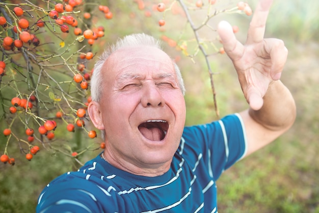 Zdjęcie wyrażanie emocji pozytywnego dziadka na emeryturze, który robi selfie